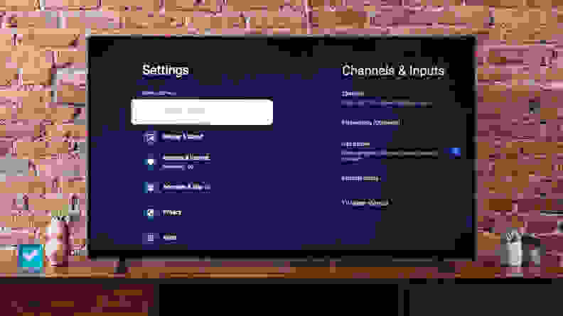 The Sony X90K LED TV on a media console in front of a brick wall, displaying its settings menu on the screen