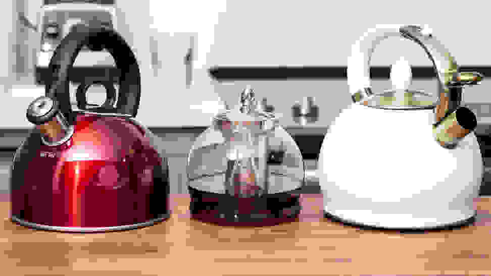 Three tea kettles, including the Cuisinart Aura, the Hiware glass kettle and the Susteas teapot, sit on a kitchen counter.