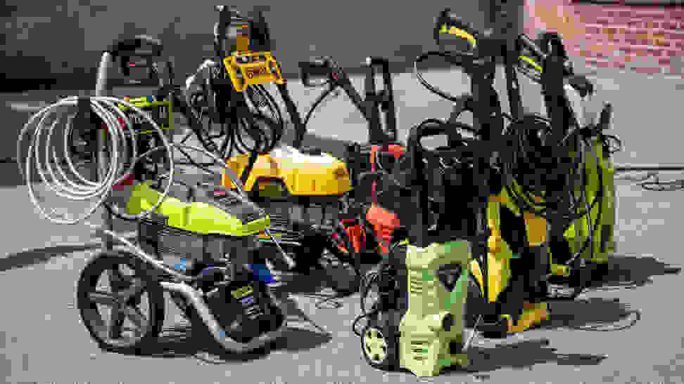 A collection of six pressure washers in a parking lot.