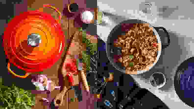 On left, an orange Le Creuset Dutch oven on a countertop surrounded by food. On right, a blue Le Creuset Dutch oven with lid removed revealing gumbo.