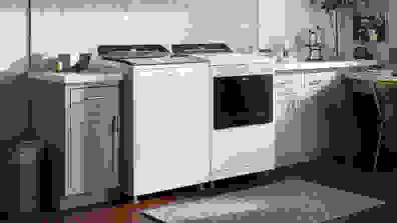 The Whirlpool WTW7120HW top-load washing machine beside a Whirlpool dryer in a laundry room.