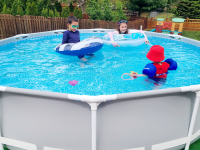 Three children swim and play in an above-ground Intex pool.