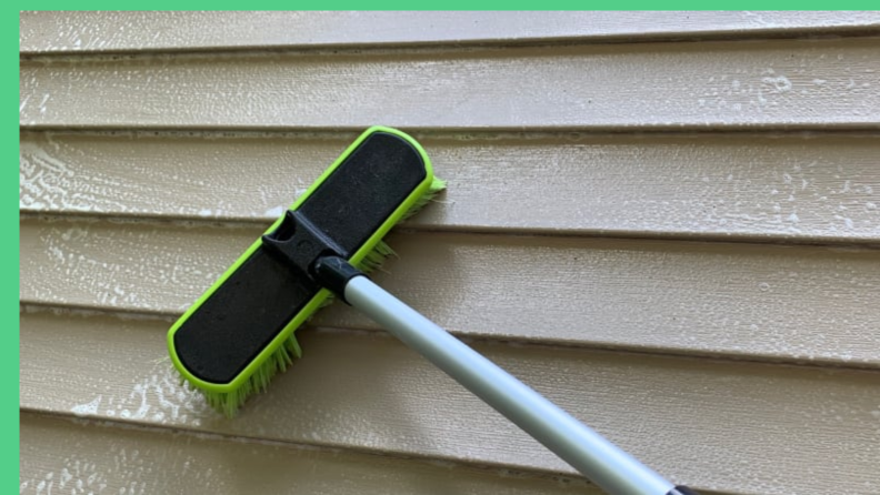 A brush and siding cleaner is used on vinyl siding for house washing.