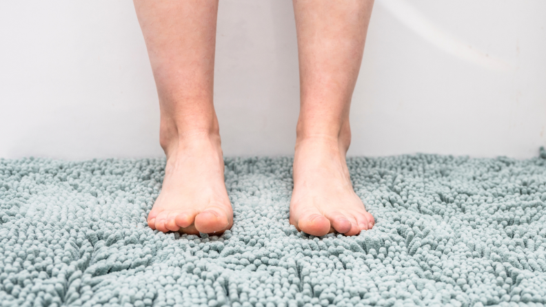 Girl standing on a bath mat.