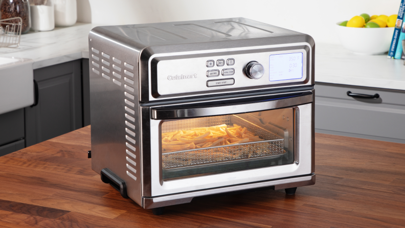 A Cuisinart Digital Air Fryer filled with french fries sits on a kitchen island.