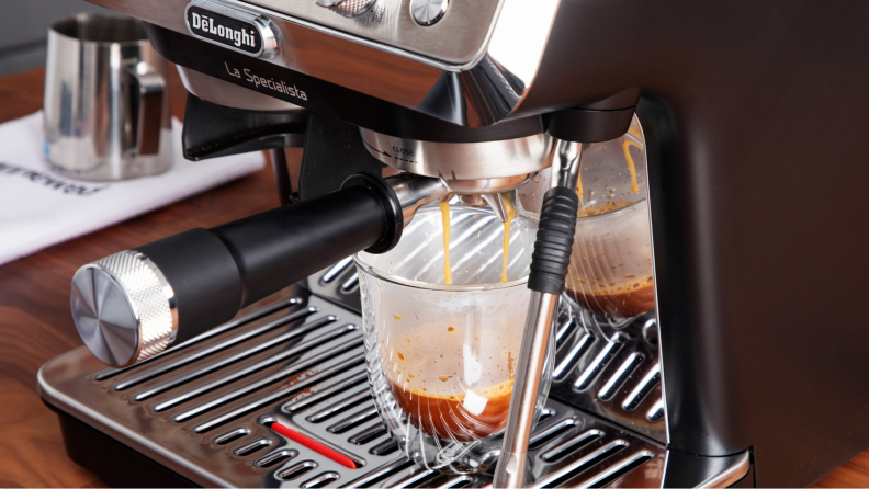 A cup being served espresso on in the machine.