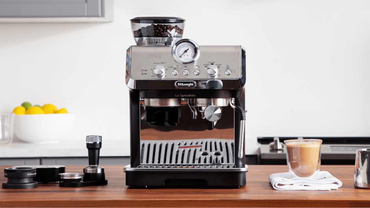 La Specialista Arte machine on a countertop surrounded by a latte and its accessories.