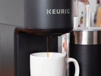 Close-up of a Keurig coffee machine brewing coffee into a white mug