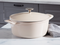 A beige Dutch oven sits on a kitchen counter.