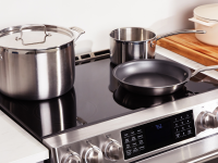 Stainless-steel pots and pans sit on an induction cooktop.