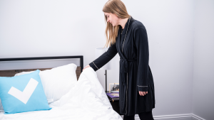 Girl pulling up her comforter in a robe.