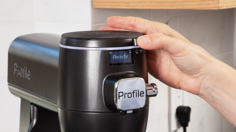 A person adjusting the GE Profile smart stand mixer controls.