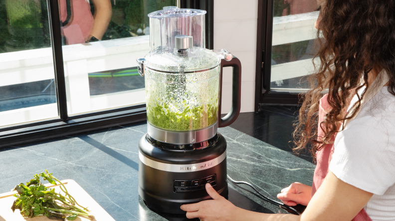 Person processing pesto in the KitchenAid food processor