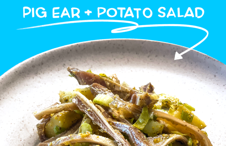 Pig ear potato salad on a white plate with a blue background.