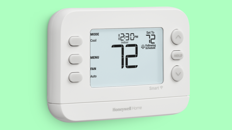 A thermostat with a clear interface and large buttons against a bright green background.