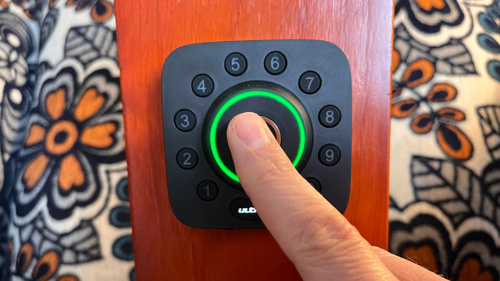 A person using the fingerprint scanner on the Ultraloq U Bolt Wi-Fi Pro smart lock