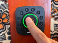 A person using the fingerprint scanner on the Ultraloq U Bolt Wi-Fi Pro smart lock