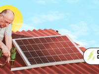 Man using drill to secure solar panel to brown roof against a blue sky.